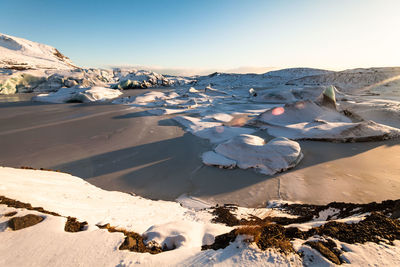 Snow covered landscape against sky