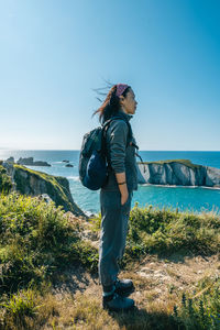 Asian girl hiking along the coast in spring during the sunset