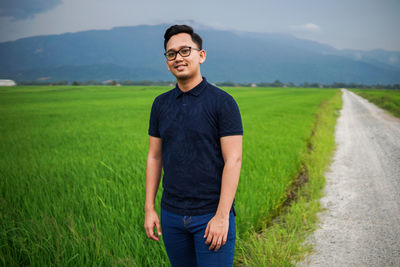 Full length of young man standing on field