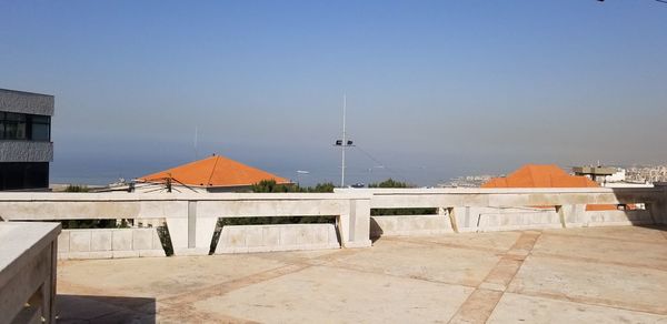 Houses by buildings against clear blue sky