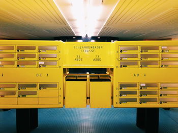 Yellow mailboxes in illuminated room