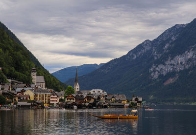 Houses by lake and mountains against sky