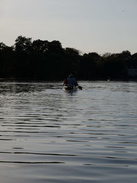 Man in boat on lake against sky