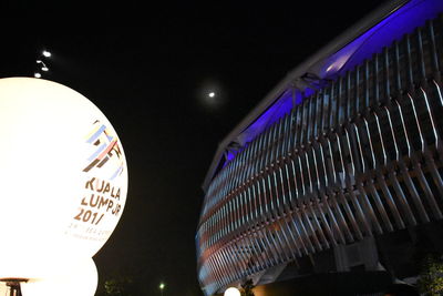 Low angle view of illuminated sign at night