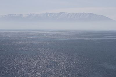 Scenic view of sea and mountains against sky