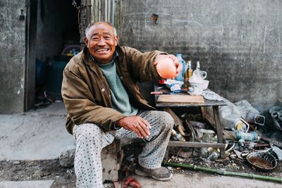 Portrait of a smiling man sitting on road