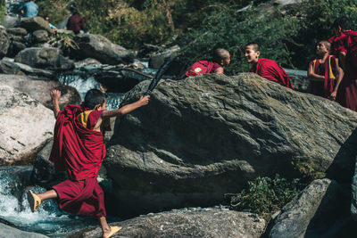 Children in traditional clothing playing on rocks