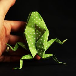 Close-up of hand holding leaf against black background