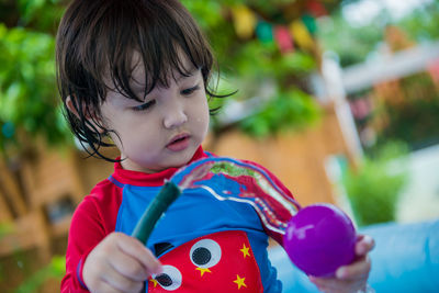 Close-up portrait of cute boy holding outdoors