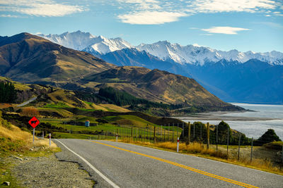 Road by mountains against sky