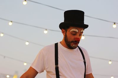 Low angle view of man in costume against illuminated lighting equipment