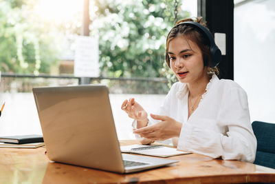 Businesswoman using laptop while sitting on table