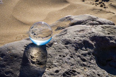 High angle view of crystal ball on rock