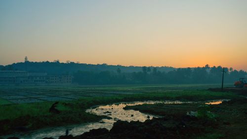 Scenic view of field against clear sky during sunset