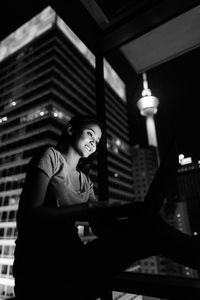 Smiling young woman looking away while sitting outdoors