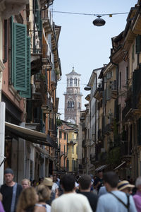 People walking on street amidst buildings in city