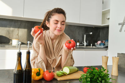 Portrait of young woman preparing food at home