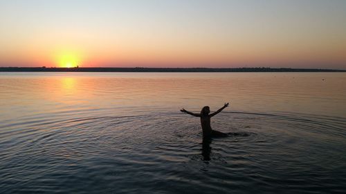 Happy girl enjoying a swim at  sunset in the southern bug river, mykolayiv region.