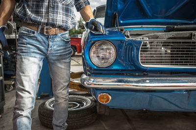 Midsection of man holding car