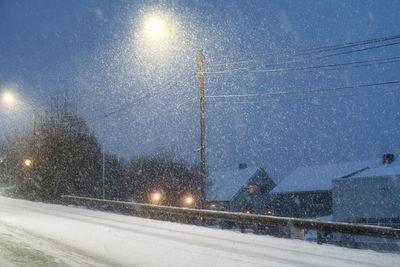 Snow covered road against sky at night