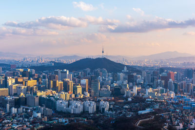 High angle view of buildings in city against cloudy sky