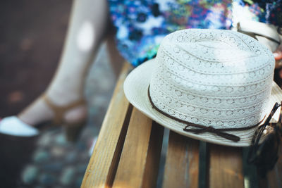 Woman sitting on bench next to hat and sunglasses