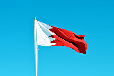 Low angle view of flag against blue sky