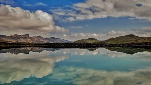 Scenic view of calm lake against cloudy sky