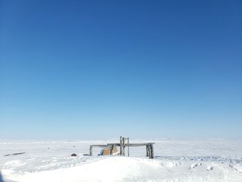 Scenic view of snow covered landscape against clear blue sky