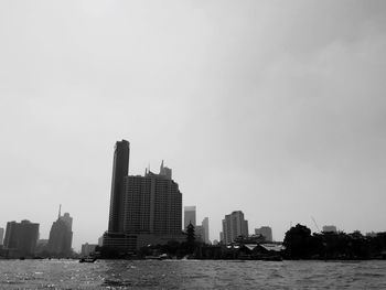 River and buildings against clear sky