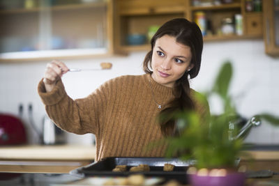 Young woman baking cookies in the kitchen