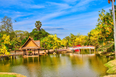 House by lake against sky