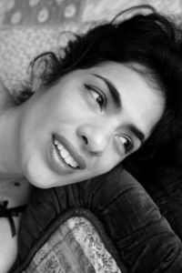 High angle view of smiling woman lying on sofa at home