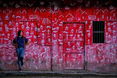 Full length of man standing against red door