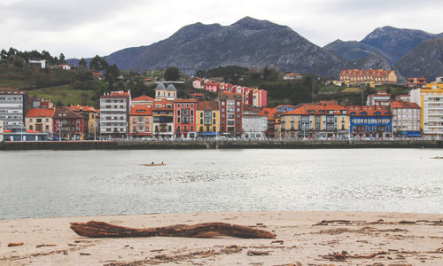 Scenic view of sea by buildings against sky