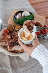 Cropped hand of woman having food on table