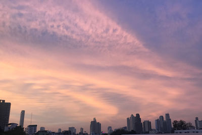 Modern buildings against sky during sunset