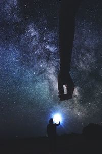 Silhouette person standing against star field at night