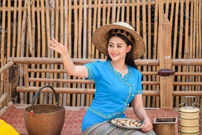 Portrait of smiling young woman sitting in basket