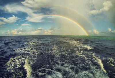 Scenic view of double rainbow over sea against sky