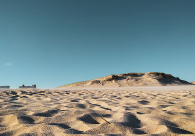 Scenic view of desert against clear blue sky