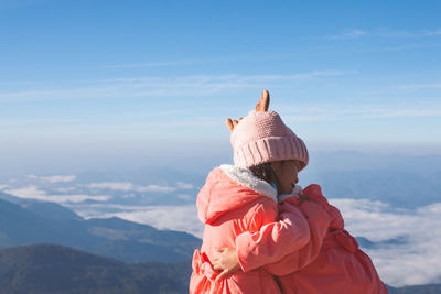 Rear view of woman in mountains against sky