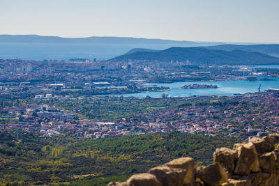 Aerial view of city by sea against sky