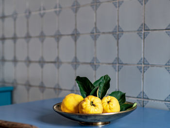 Close-up of fruits on table against wall