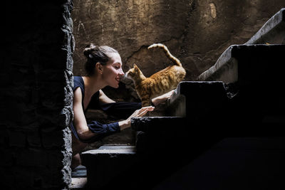 Young woman using smart phone while sitting in laptop