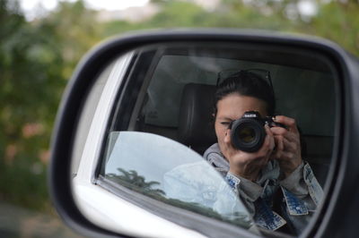 Close-up of young woman holding camera