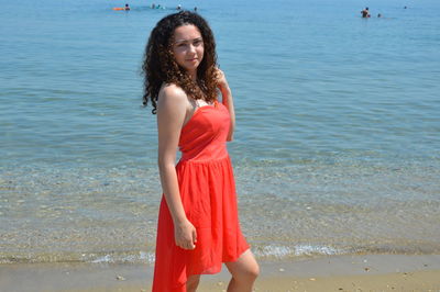 Portrait of smiling young woman standing at beach