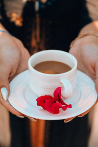 Midsection of woman holding coffee cup