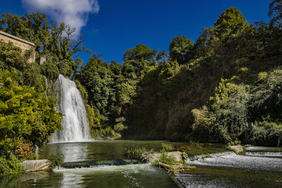 Scenic view of waterfall against sky