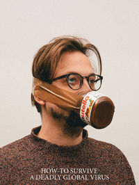 Portrait of young man wearing eyeglasses against white background